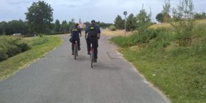 Zdjęcie przedstawia strażników miejskich jadących rowerami