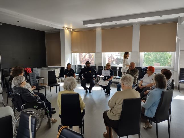 Zdjęcie przedstawia osoby obecne na prelekcji w temacie zagrożeń bezpieczeństwa osób starszych dla seniorów w Senior-Wigor w Luboniu